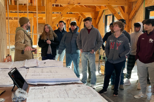   Students listening to a presentation at a build site